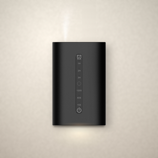 Phynix Fire Studios Waterless Diffuser MINI in black aluminum alloy, front view, plugged into a wall outlet
