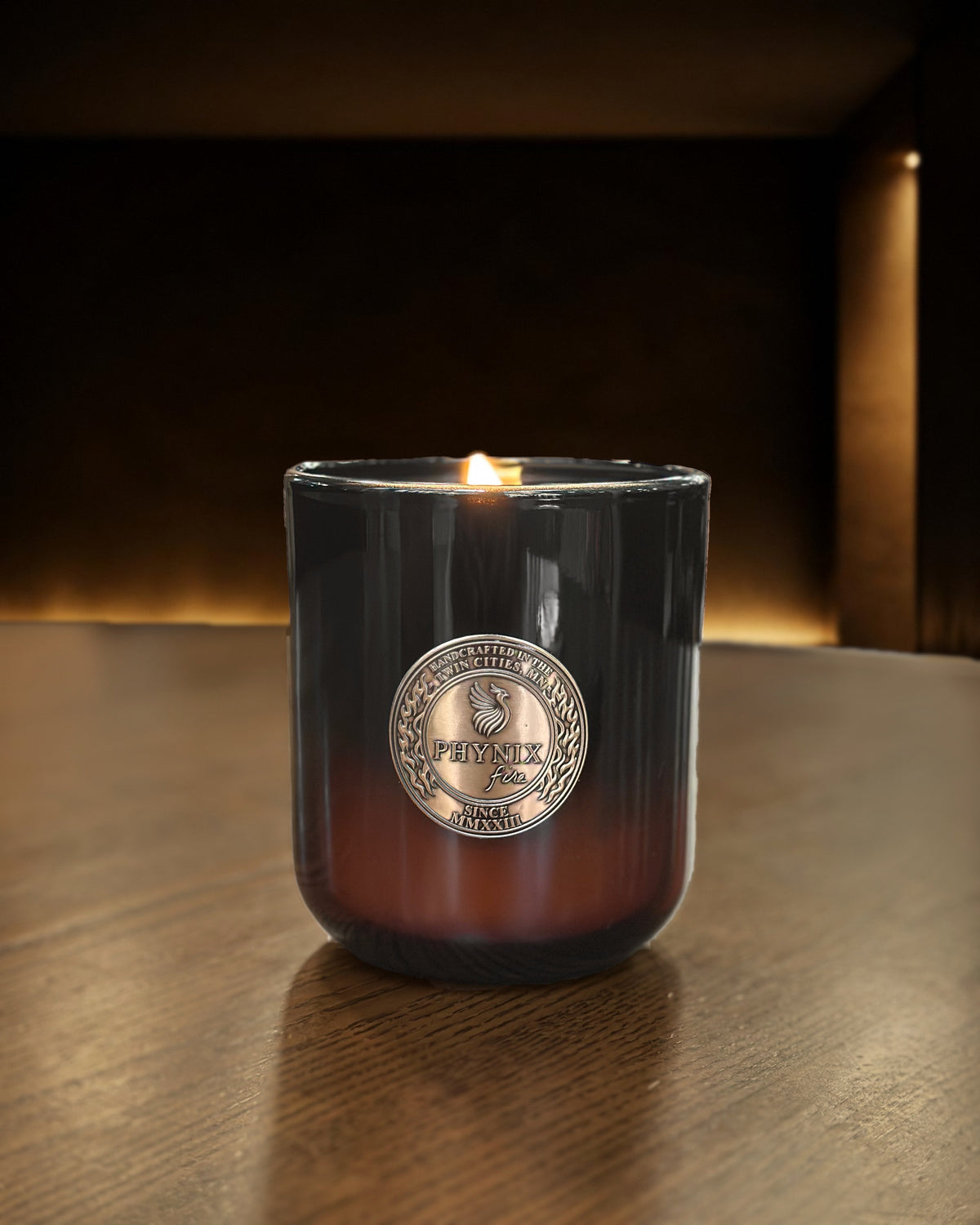 AMOR NOIR Luxury Candle in the PARVUS 8 oz vessel, lit, on a walnut table