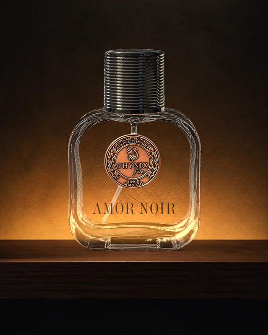 AMOR NOIR 50 mL Parfum by Phynix Fire Studios — clear glass bottle with copper coin seal, a dark room with a low amber glow on a dark wood shelf
