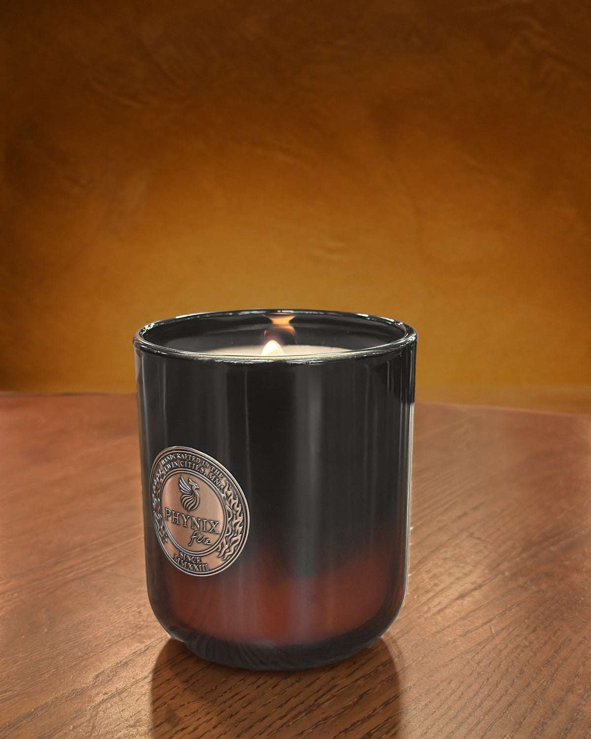 AUREUS Luxury Candle in the PARVUS 8 oz vessel, lit, in a warm interior