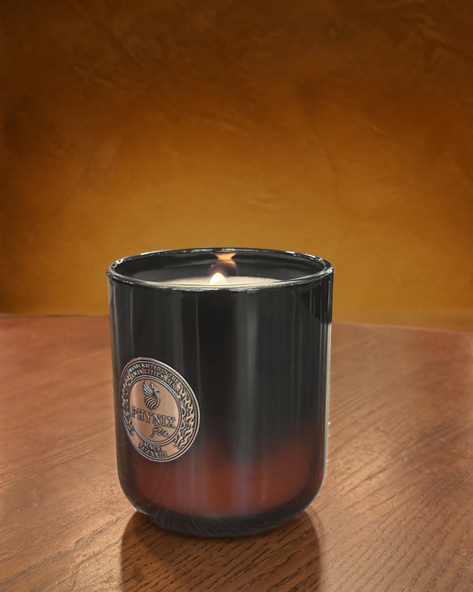 AUREUS Luxury Candle in the PARVUS 8 oz vessel, lit, in a warm interior