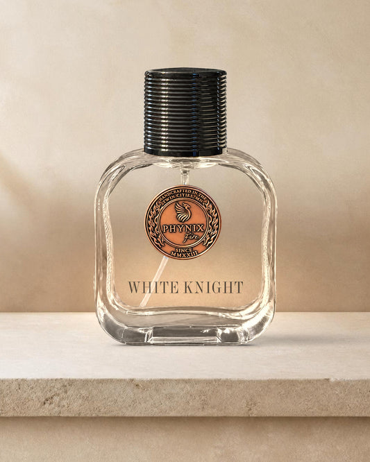WHITE KNIGHT Limited Edition 50 mL Parfum by Phynix Fire Studios — clear glass bottle with copper coin seal, seamless warm-bone plaster on a pale limestone shelf